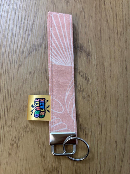 Pink keychain with a metal ring on a wooden surface